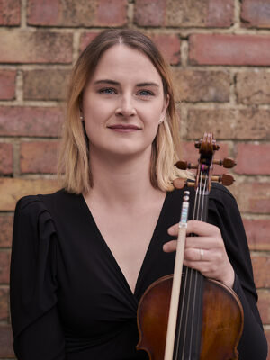 A woman holding their violin